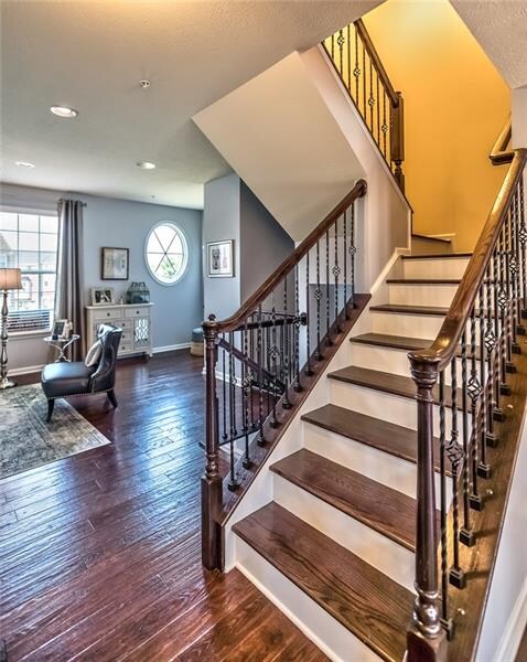 Gleaming Hardwood Floors and Staircase with Custom Wrought Iron Railings