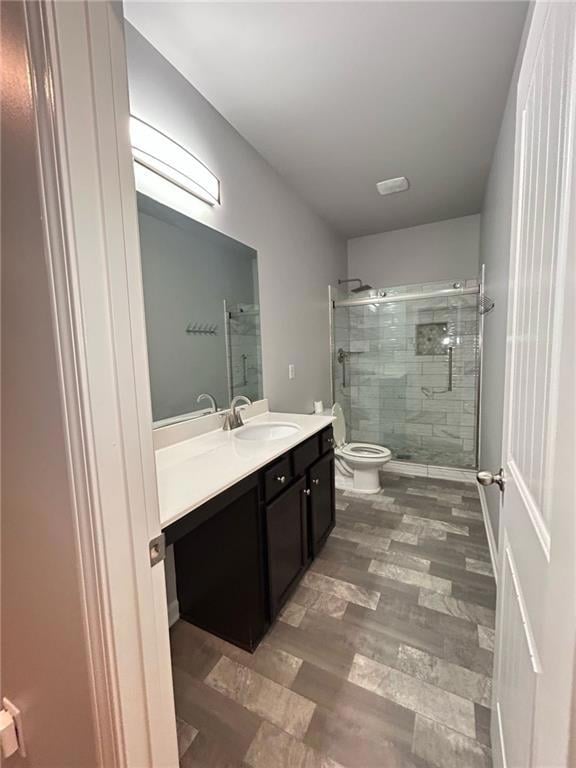 Full bathroom featuring vanity, a stall shower, and wood finished floors