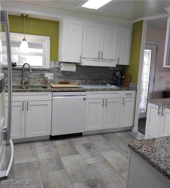 Kitchen featuring white dishwasher, sink, white ca