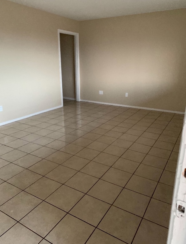 Living room with light tile patterned floors and baseboards
