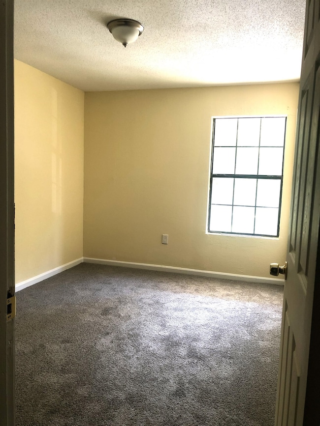 Empty room with carpet floors and a textured ceili