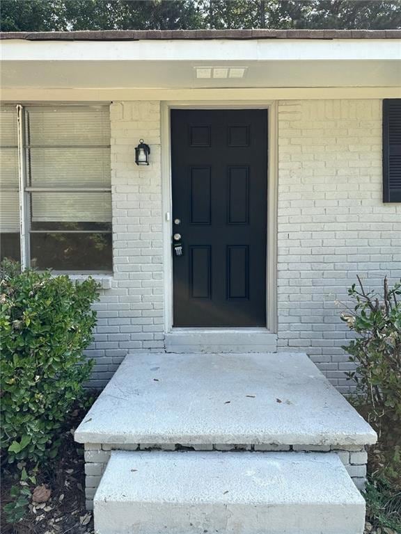 View of exterior entry featuring brick siding