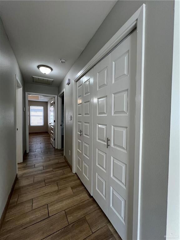 Hall featuring dark wood finished floors and baseboards