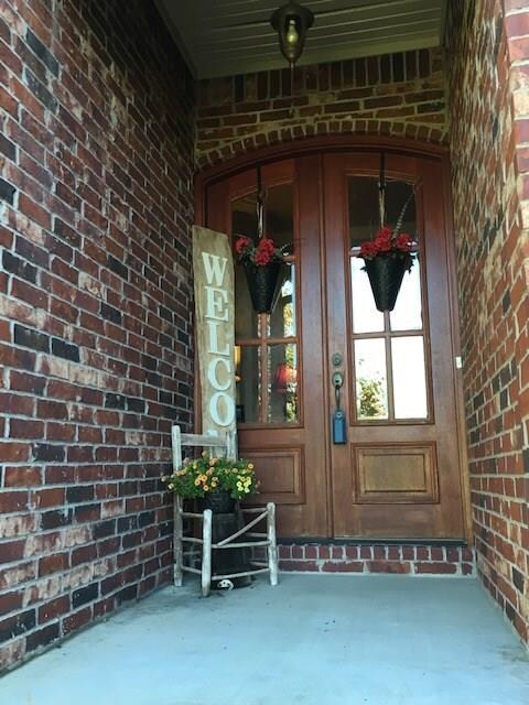 The very welcoming covered front porch with heavy wood front doors and lots of glass windows for light and visibility.