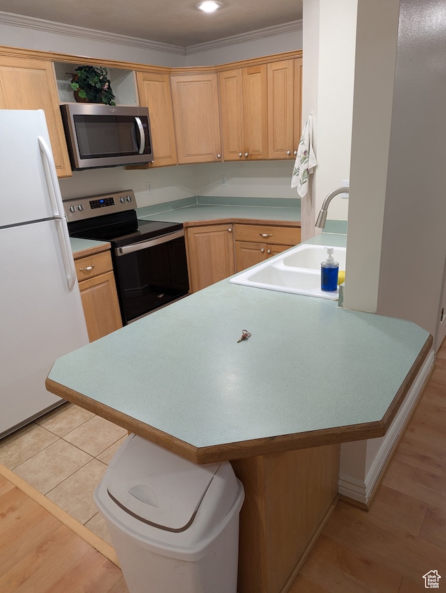 Kitchen featuring a breakfast bar, light countertops, appliances with stainless steel finishes, crown molding, and open shelves