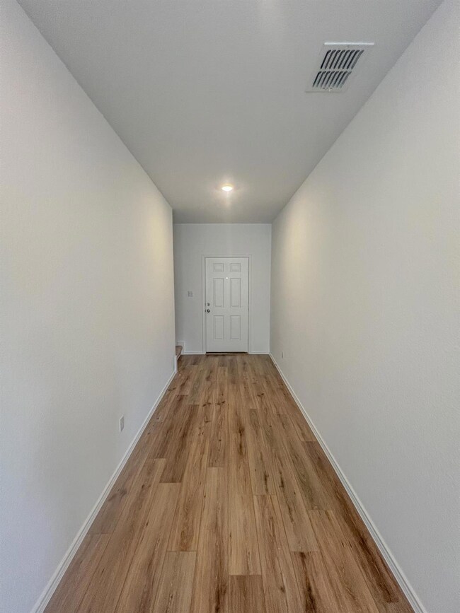 Hallway featuring light wood finished floors and baseboards