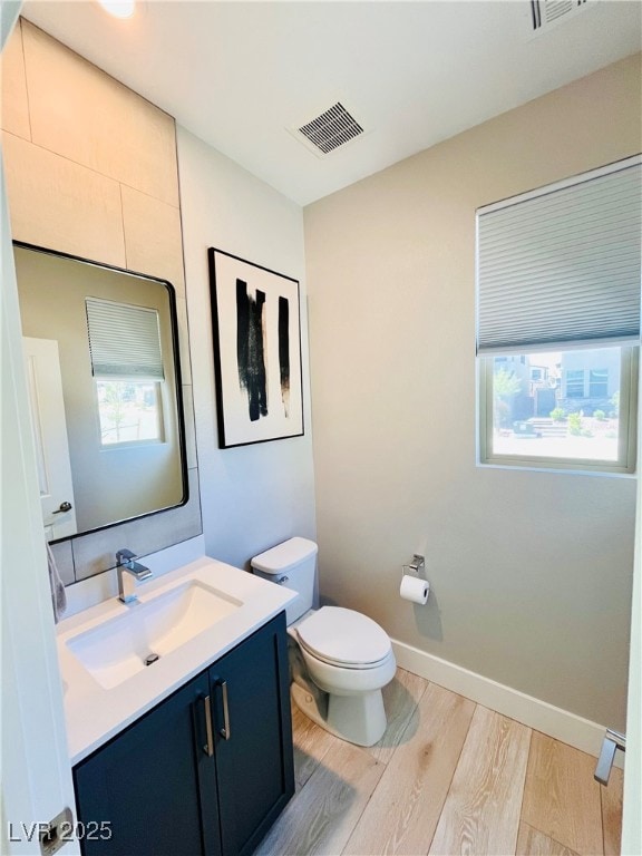 Bathroom featuring wood finished floors, toilet, v