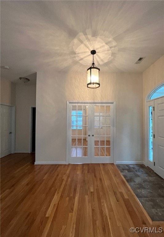 Foyer featuring french doors, wood finished floors