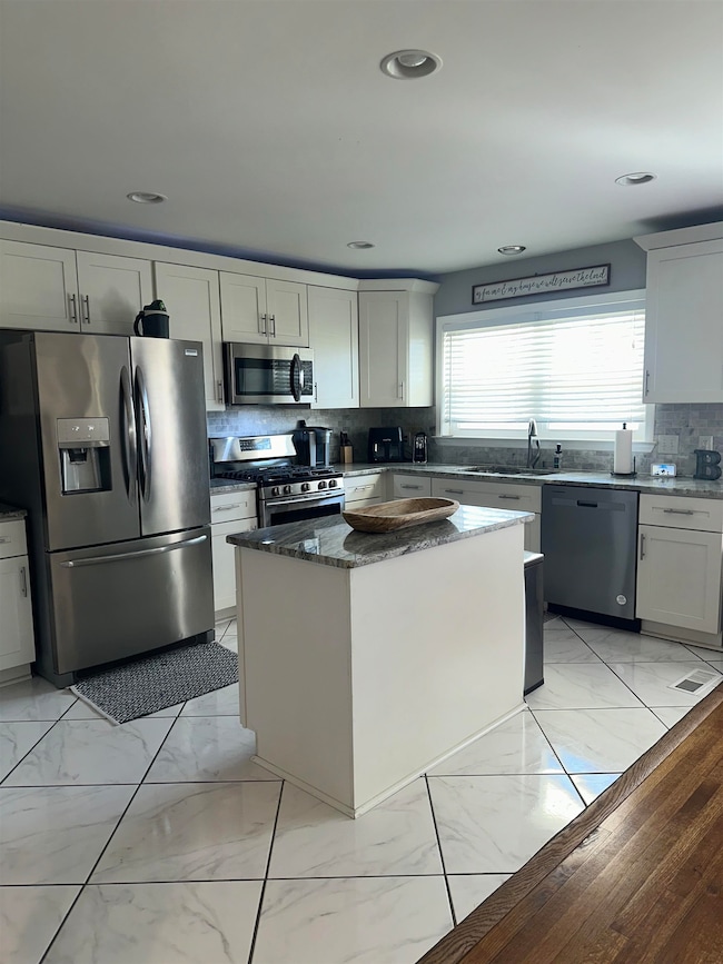 Kitchen featuring marble finish floor, a sink, tas