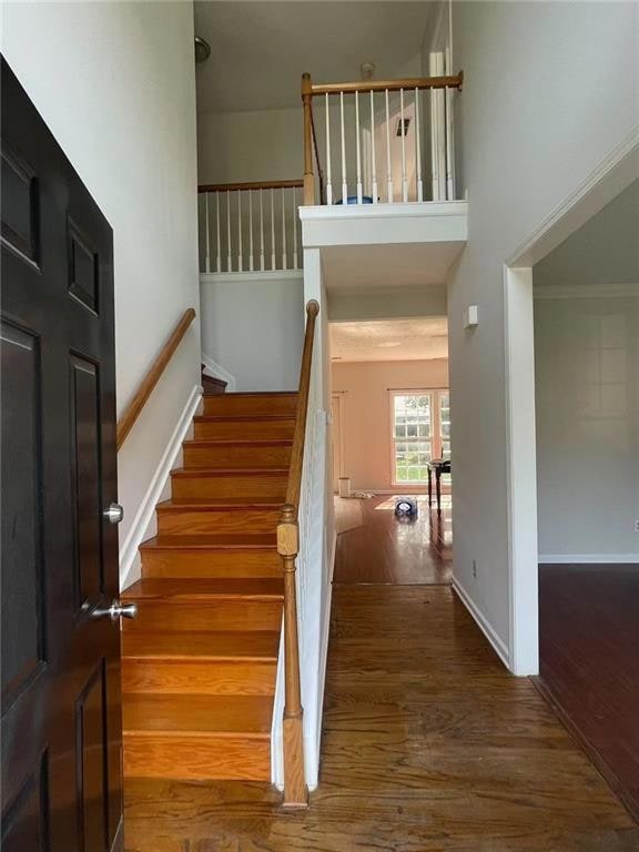 Stairs featuring wood finished floors and baseboards