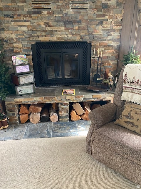 Detailed view of carpet flooring and a glass covered fireplace