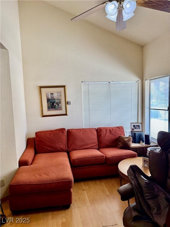 Living area featuring a ceiling fan, light wood-st