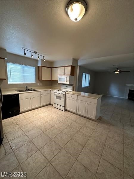 Kitchen featuring a sink, white appliances, a peni