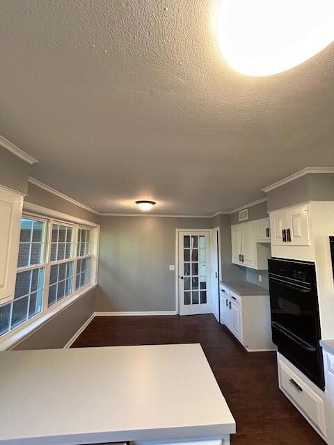 Kitchen featuring white cabinets, crown molding, d