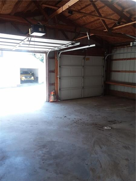 Garage has concrete floor, and two auto door opene