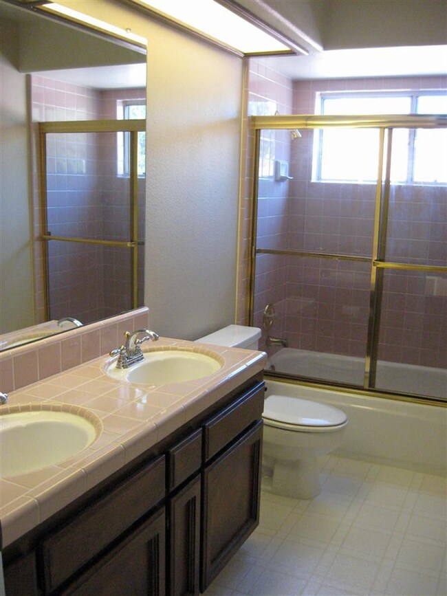 Upstairs bathroom with double sinks and tiled tub/