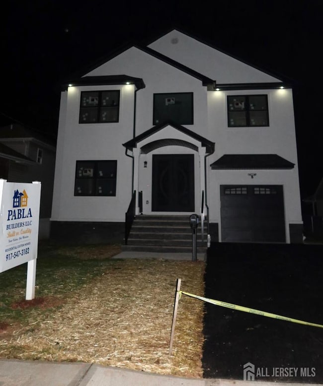 view of front of home featuring a garage, stucco siding, and asphalt driveway