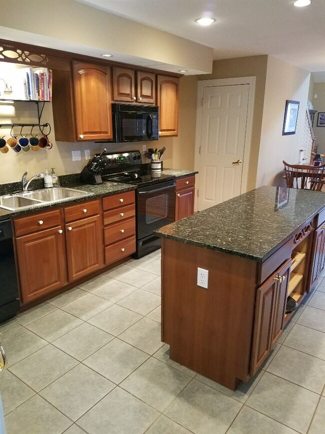 Cherry cabinets, black granite counters, center is