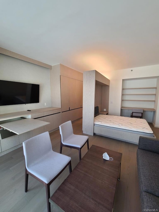 Bedroom with wood finished floors and a closet