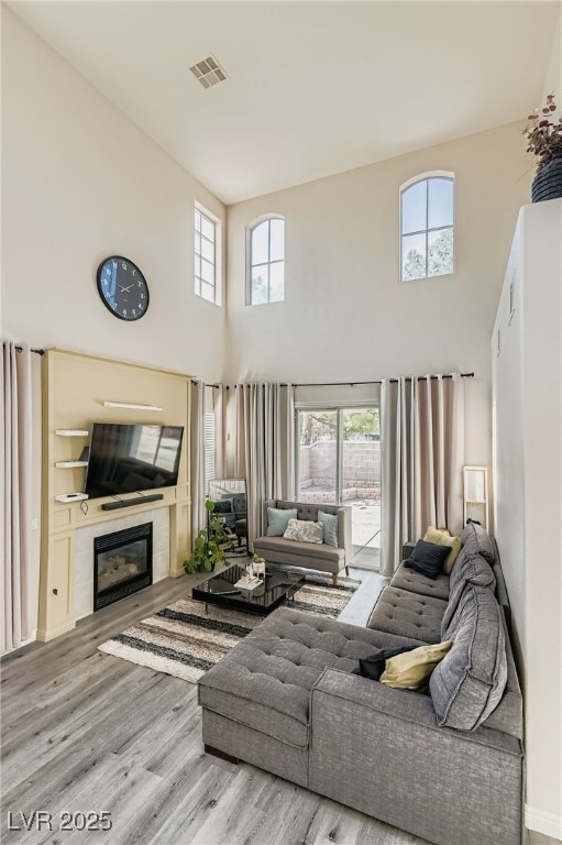 Living room with wood finished floors, a glass cov