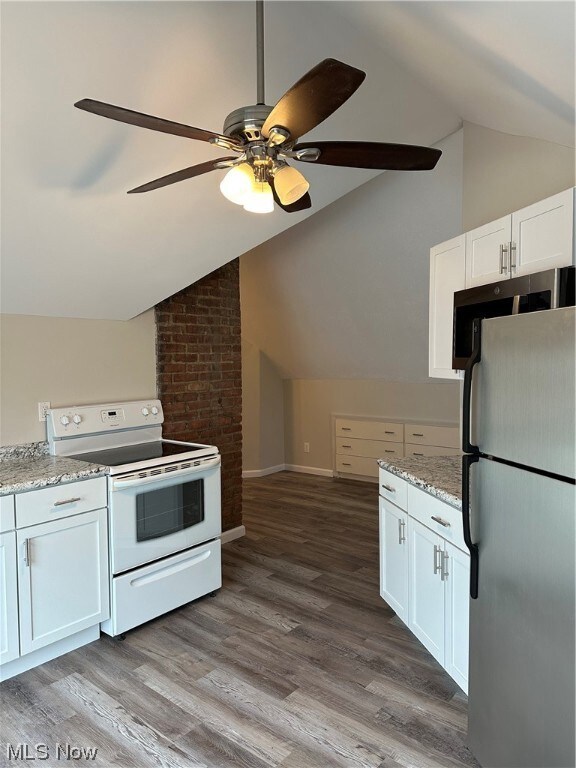 Kitchen featuring ceiling fan, white cabinetry, fridge, range, and hardwood / wood-style flooring