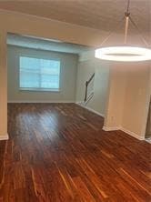 Empty room featuring dark wood-type flooring