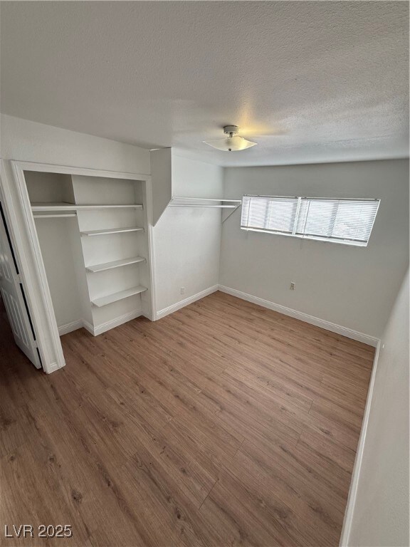 Unfurnished bedroom with baseboards, wood finished