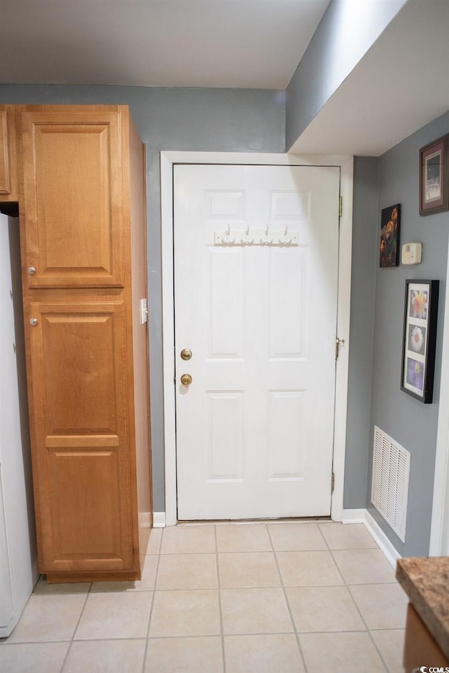 Entryway with visible vents, baseboards, and light