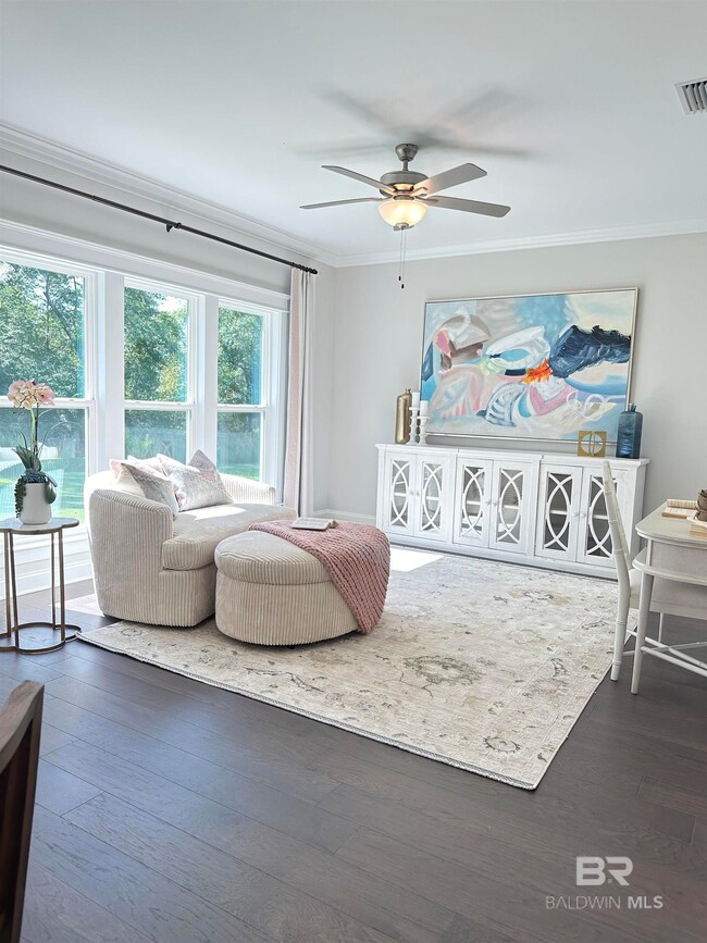 Bedroom with ceiling fan, crown molding, and wood-type flooring