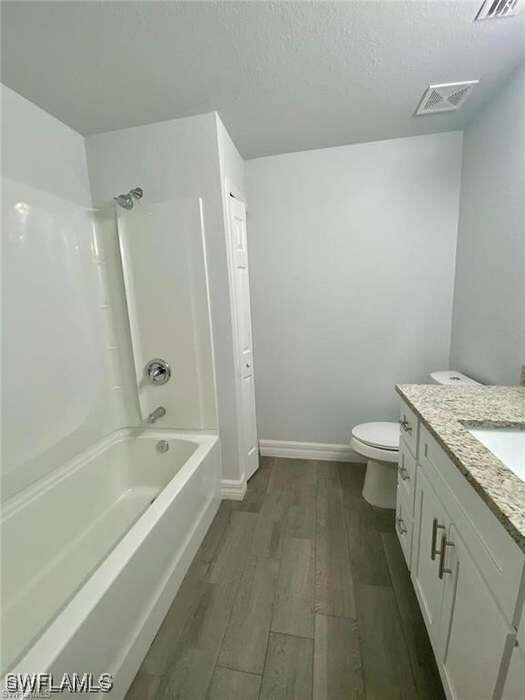 Full bath featuring wood finished floors, vanity,