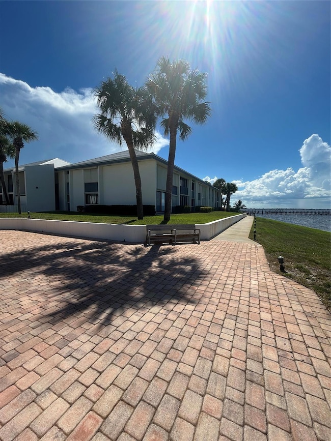 View of building from the club house/ pool/ and lounging/ picnic area/  outside gathering area in front of private beach and pier/ dock
