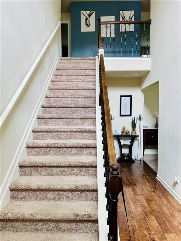 Stairway with wood finished floors and baseboards
