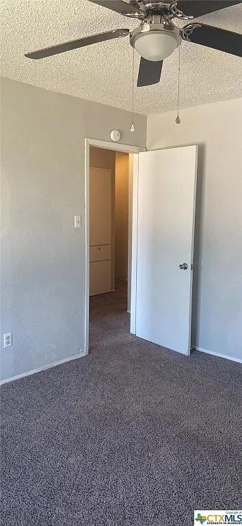 Carpeted spare room featuring ceiling fan and bas