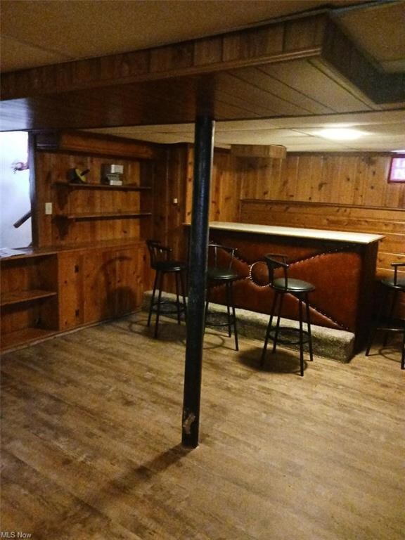 Basement with wood walls and light hardwood floors