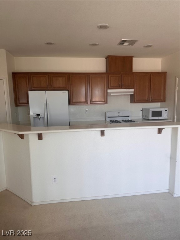 Kitchen featuring fridge, brown cabinetry, a break