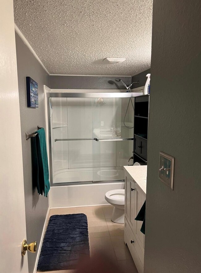 Full bathroom featuring tile floors, vanity, enclo