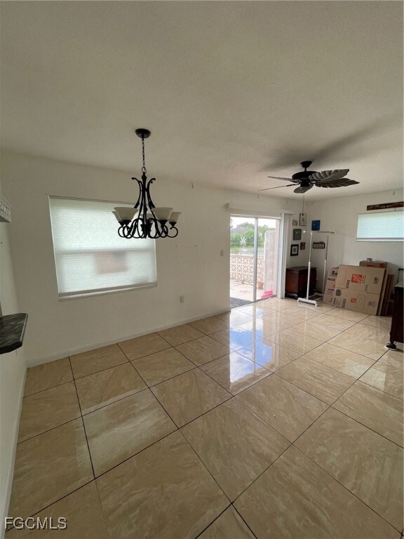 liing room with a ceiling fan, light tile patterned floors, and a chandelier