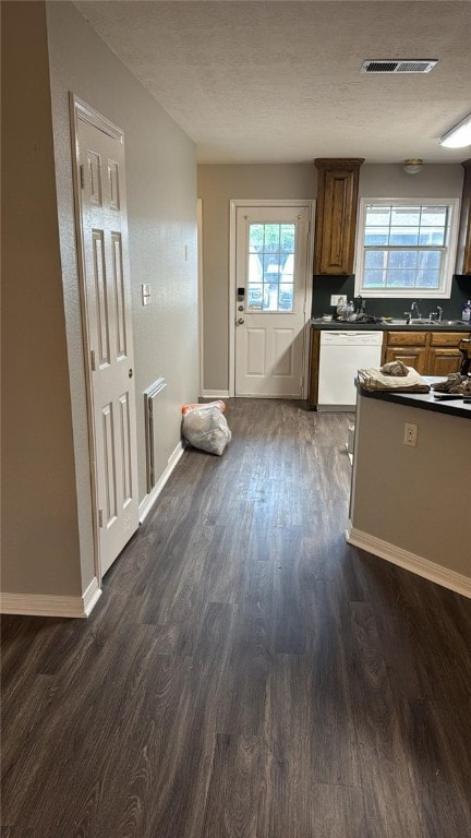 Kitchen with dishwasher, dark countertops, dark wo