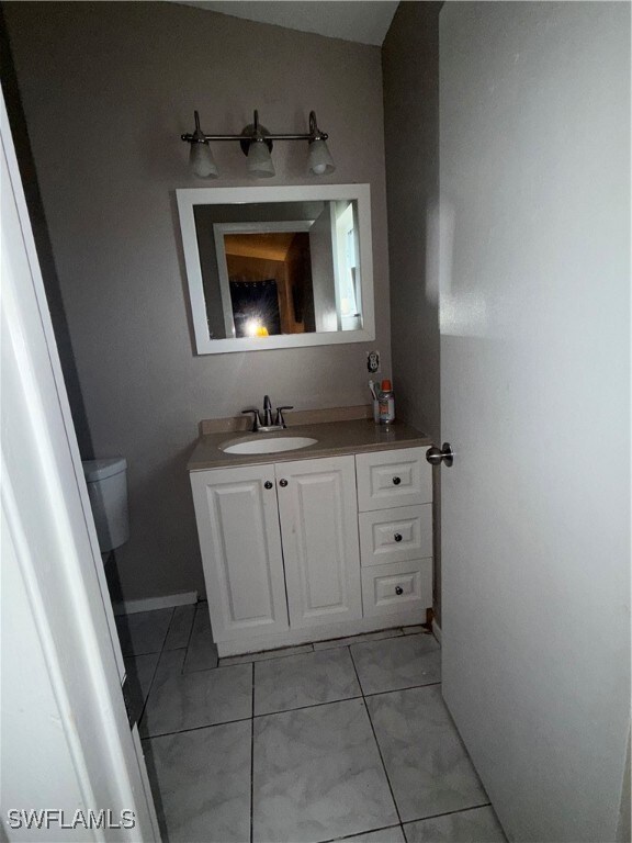 Half bath featuring vanity and tile patterned floo