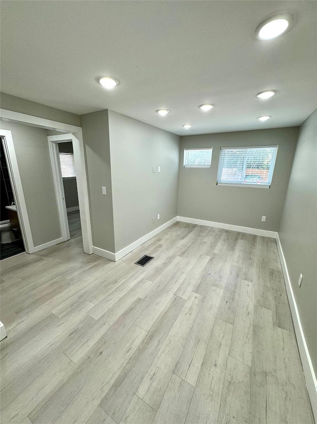 Basement with light hardwood / wood-style floors