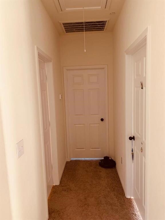 Hall with attic access and carpet