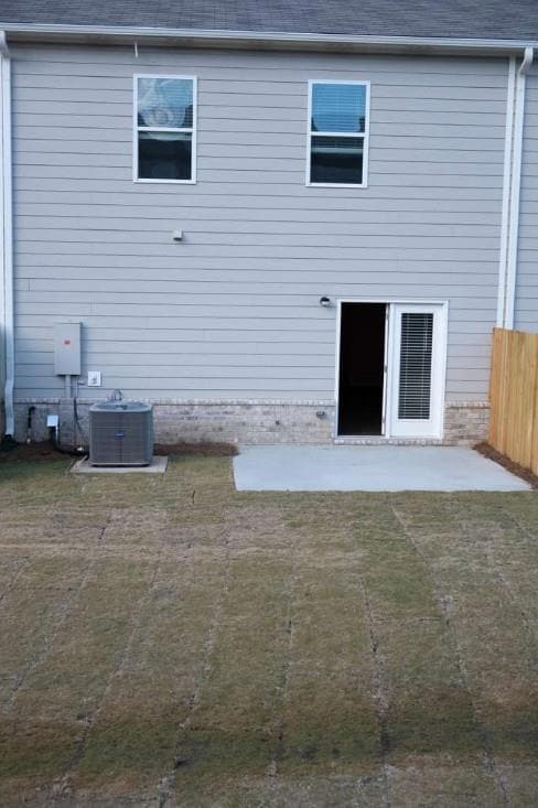 Rear view of house featuring a patio area and roof with shingles