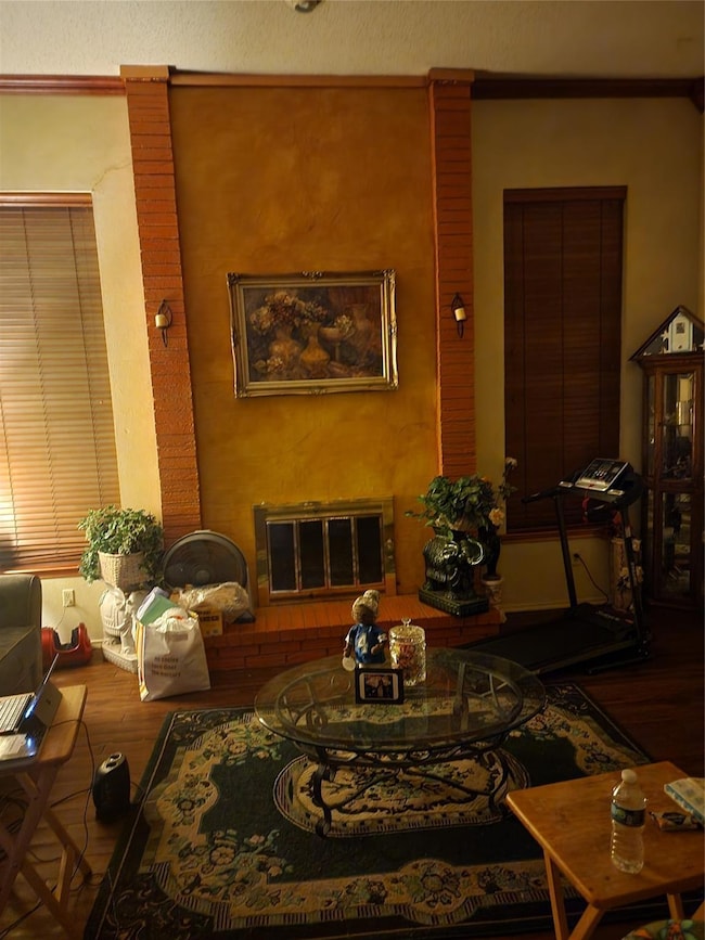 Living room featuring wood-type flooring, a brick 