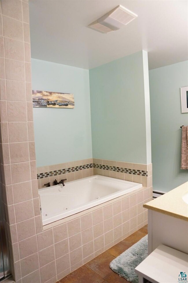 Large jacuzzi tub and separate tiled shower.