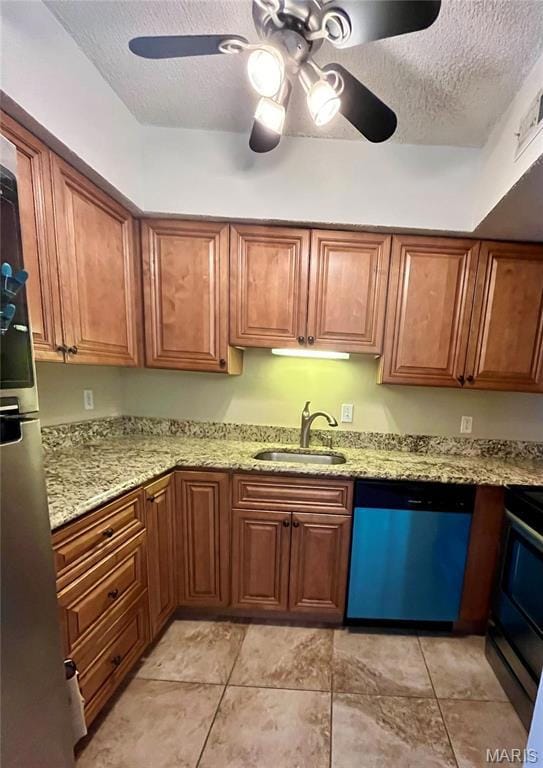 Kitchen featuring freestanding refrigerator, a textured ceiling, a ceiling fan, dishwasher, and a sink