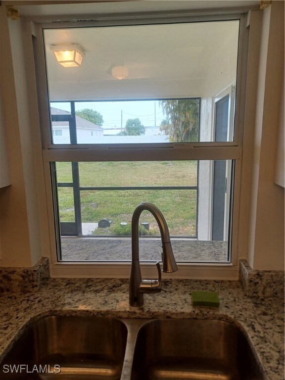 Details featuring light stone countertops and a si
