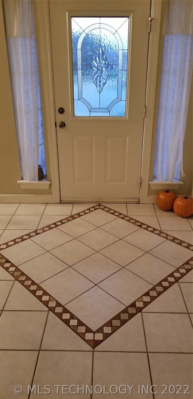 Well lit entry way to the home with custom tile