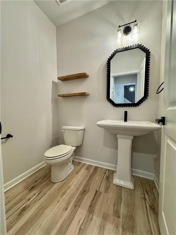 Half bath with light wood-style flooring and baseboards