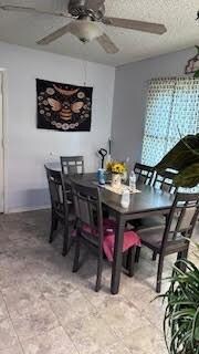 Tiled dining room featuring ceiling fan