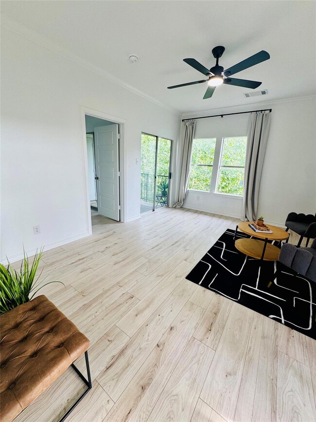 Living area featuring crown molding, ceiling fan,